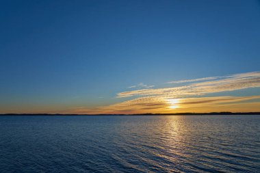 Güneşin ufuktan ayrıldığı Baltık Denizi 'nde renkli bir gün batımı..