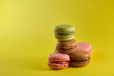 Sarı arkaplan aromalı badem kurabiyeleri pastel renkler ve metin için boşluk.