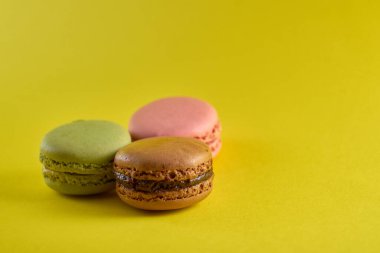 Sarı arkaplan aromalı badem kurabiyeleri pastel renkler ve metin için boşluk.