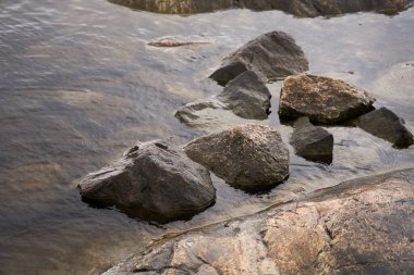 Kayalık sahildeki suda gökyüzünün yansıması.