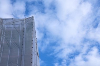 Beyaz bulutlu mavi gökyüzüne karşı inşaat iskelesi