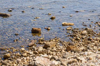 Girit 'teki sıcak tropikal denizin kıyısındaki taşlar.