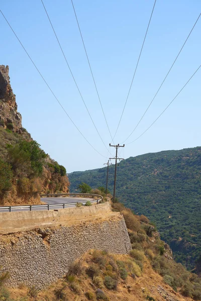 Mountain road and line of electric transmissions in the mountains of Crete