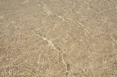 Girit 'teki tropikal kumlu plajda temiz suyun yüzeyi