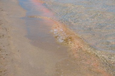 Girit 'teki tropikal kumlu sahilde berrak dalgalar ve renkli kumlar