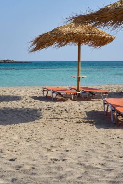 Tropikal kumlu sahilde turkuaz deniz suyuna karşı güneş gözlüğü..