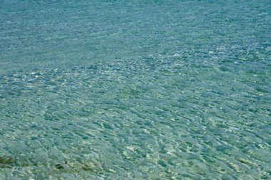 Girit 'teki tropikal kumlu plajda temiz suyun yüzeyi