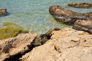 Girit Yunanistan 'da taşlı tropikal kumlu plajda berrak su yüzeyi.
