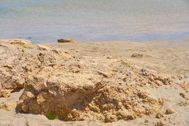 Girit Yunanistan 'da taşlı tropikal kumlu plajda berrak su yüzeyi.