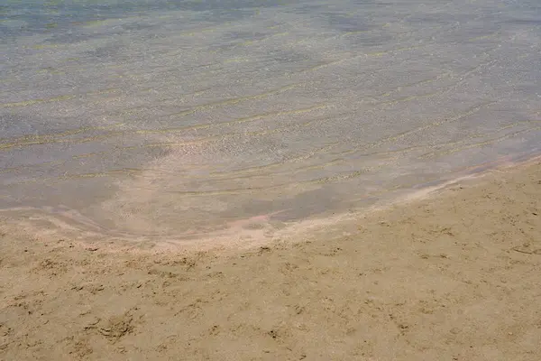 Heldere golven en kleurrijk zand op tropisch zandstrand op Kreta Griekenland. — Stockfoto