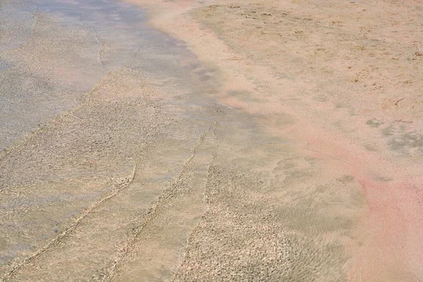 Ondas claras e areia colorida na praia tropical de areia em Creta Grécia. — Fotografia de Stock