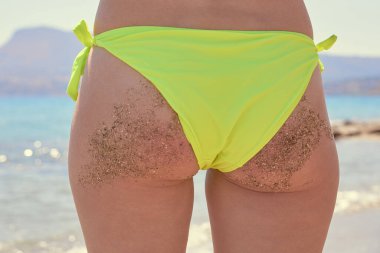 Tropikal bir plajda parlak bikinili beyaz bir kadın.