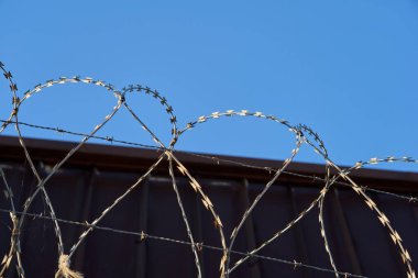 Mavi, berrak gökyüzüne karşı dikenli tel