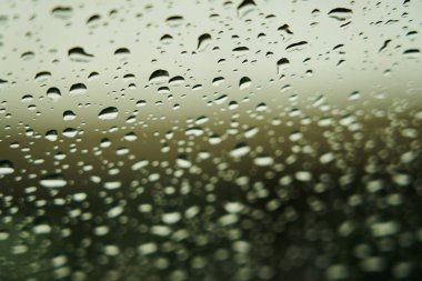 Yağmur damlaları ile arka plan bulanık cam üzerinde
