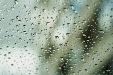 Yağmur damlaları ile arka plan bulanık cam üzerinde