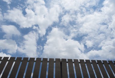 Mavi gökyüzü arka plan ile kahverengi çit.