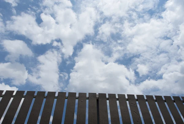 Brązowy ogrodzenia, z tle błękitnego nieba. — Zdjęcie stockowe