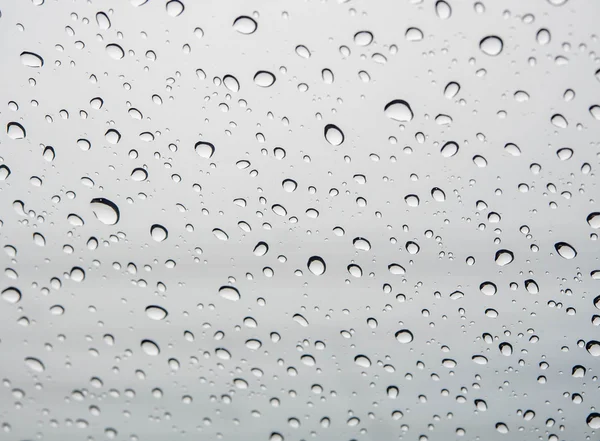 许多人困在挡风玻璃背景的雨滴. — 图库照片