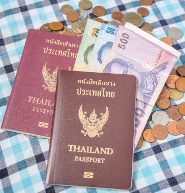Paralar baht para yığını üzerinde pasaport ve Tayland banknot para birimi.