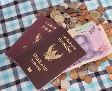 Paralar baht para yığını üzerinde pasaport ve Tayland banknot para birimi.
