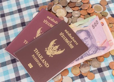 Paralar baht para yığını üzerinde pasaport ve Tayland banknot para birimi.