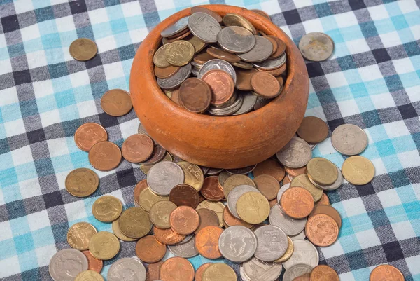 Stapel van munten Baht-valuta is gegoten uit de aardewerk cup. — Stockfoto