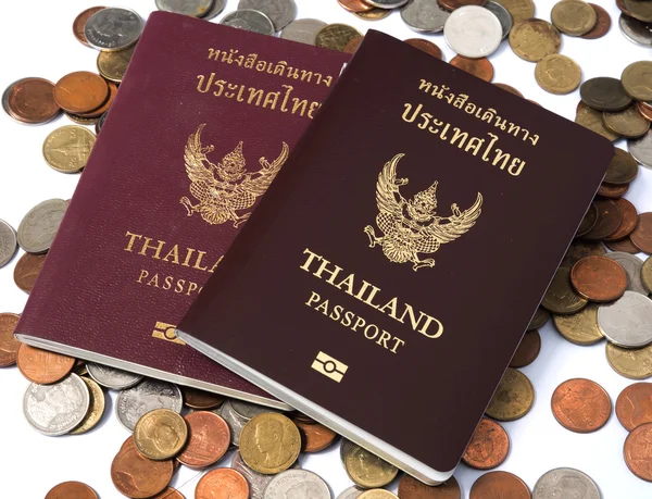 Dos Pasaporte de Tailandia poner en la pila de monedas baht moneda sobre fondo blanco . — Foto de Stock