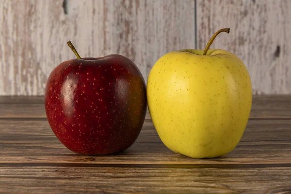 Meyveler, elmalar ahşap bir masanın üzerinde çevre ışığı olan bir masada, sağlıklı, organik olarak bir çiftlikte üretiliyor..
