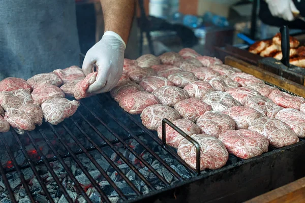 Cucinare rendendo hamburger all'aperto su evento festival street food — Foto Stock