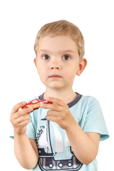 Un niño pequeño con grandes ojos sosteniendo un coche de juguete sobre un fondo blanco — Foto de Stock