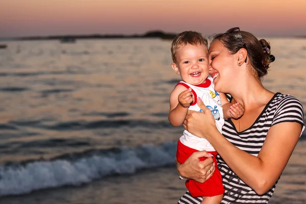 mother and son by the sea at sunset
