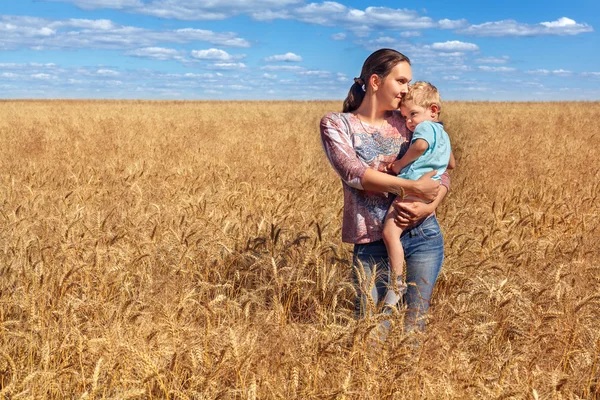 young mother and her son at the wheat field on a sunny day