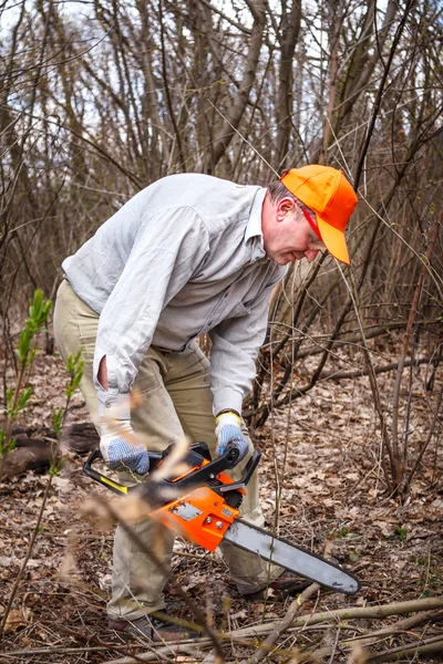 Woodman gebruikt zijn kettingzaag knippen de boom — Stockfoto