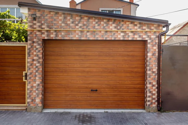 Houten garagedeur met gekleurde bakstenen muur achtergrond — Stockfoto