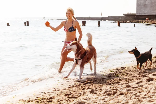 Köpek ile sahilde koşan genç kız