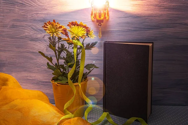 light from a candle on a background of books and flowers