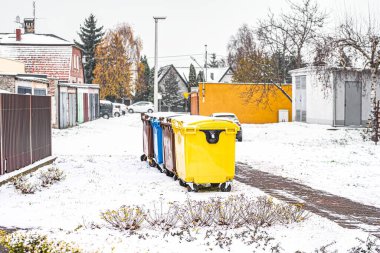 Atık ayrımcılığı için bir sıra renkli çöp kovası. Kış arka planında