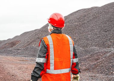 Başı korumak için bir kask. Madencilik endüstrisi. Yansıtıcı şeritli bir yelek. İşçi koruması