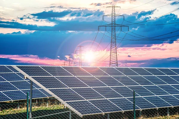 Solar panels with electricity pylons at sunset ,  power plant