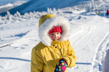 Kışın sıcak bir ceketle karda bebek.