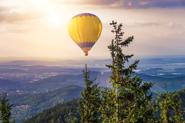 Mavi gökyüzünün ortasında bir balon. Bulutlarda süzül