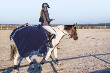 Jokey ata biniyor, binicilik yapıyor.