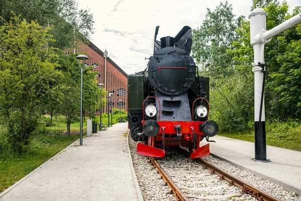 Steam locomotive with headlights on the railway track , Black steam locomotive with red wheels, Poland