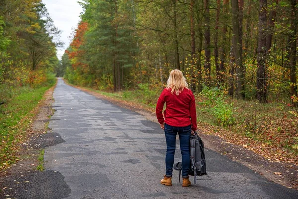 A young girl stands on the road and tries to stop the car