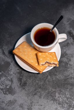 Çay ya da çay, çay fincanında çay kaşığı ve kurabiyeyle. Yakın plan. Seçici odak.