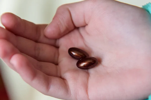 Brown capsules in the hand. Drink pills. Treatment. Recovery. Tablets from the virus.