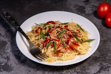 Domatesli makarna, sos, peynir ve Provencal otlar. Karanlık arka plan. Kopyalamak için yer var. Üst Manzara. Domates soslu makarna İtalyan usulü.