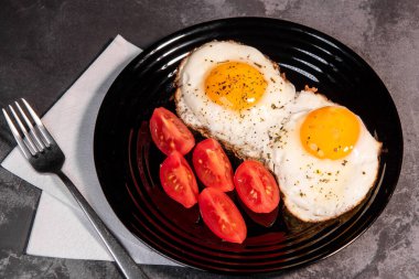 Kızarmış yumurta ve tost, ekmek, domates, lezzetli kahvaltı, aperatif, yumurta sarısı ve protein yiyecekler, arka plan, üst görüş, fotokopi alanı, sağlıklı hammaddeler. Çırpılmış yumurta. Kahvaltıda. Sağlıklı beslenme. Yakın plan.