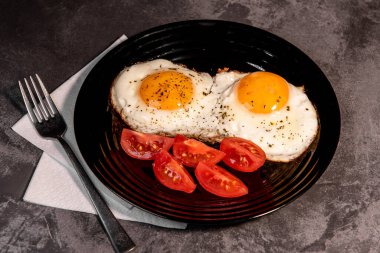 Kızarmış yumurta ve domates dilimleri, lezzetli kahvaltı, aperatif, yumurta sarısı ve protein yiyecekler, arka plan, üst görüş, fotokopi alanı, sağlıklı hammaddeler. Çırpılmış yumurta. Kahvaltıda. Sağlıklı beslenme. Yakın plan.
