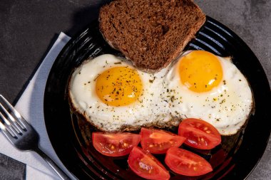 Kızarmış yumurta ve tost, ekmek, domates, lezzetli kahvaltı, aperatif, yumurta sarısı ve protein yiyecekler, arka plan, üst görüş, fotokopi alanı, sağlıklı hammaddeler. Çırpılmış yumurta. Kahvaltıda. Sağlıklı beslenme. Yakın plan.